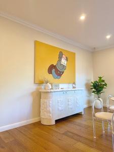 a living room with a wall with a mickey painting at Hampton Luxe Designer Retreat with Park Views in Melbourne
