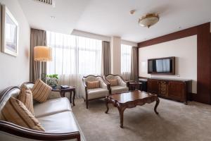 a living room with a couch and a tv at Tang Palace Hotel in Accra
