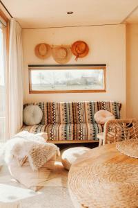 a living room with a couch and a window at Tiny Cabana in Scharendijke