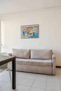 a couch in a living room with a painting on the wall at Harbour View Apartment - Elite Grado Centro in Grado