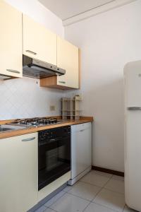 a kitchen with white cabinets and a black oven at Harbour View Apartment - Elite Grado Centro in Grado