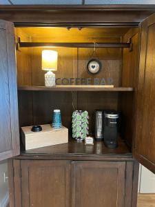 a cupboard with a coffee maker and a lamp on it at Beacon Hudson Hideaway in Beacon