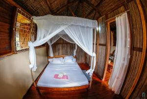 a bedroom with a bed with a canopy at Antafondro Lodge in Sainte Marie