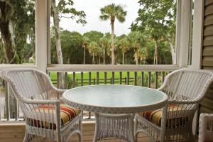 a porch with a table and two chairs and a window at Ocean Ridge Resort 2BR Apartment in Edisto Island +47 photos