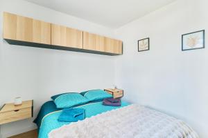 a bedroom with a bed with blue pillows at Le Cocon de Brocéliande - Studio cosy et indépendant in Saint-Thurial