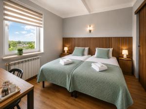 a bedroom with two beds and a window at Willa Fenix Busko-Zdroj Pokoje Goscinne & Agroturystyka in Busko-Zdrój