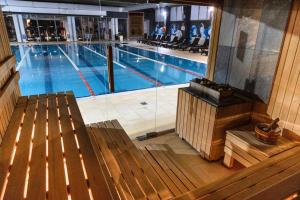 a swimming pool with a bench in front of it at Hotel Moldova in Iaşi