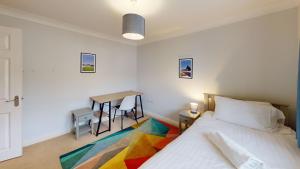 a bedroom with a bed and a table with chairs at Walnut Cottage in Brackley