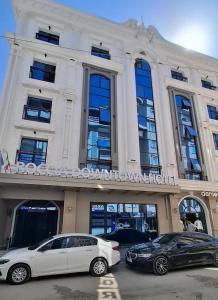 two cars parked in front of a building at Roccia DownTown Otel in Van
