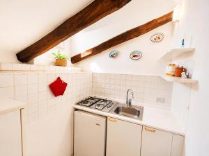 a kitchen with a sink and a stove at Casa al mare Porto Sole in Baja Sardinia