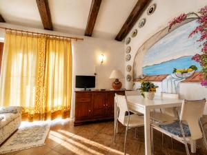 a living room with a table and a tv at Casa al mare Porto Sole in Baja Sardinia
