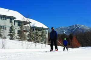a man and a child on skis in the snow at Smugglers' Notch Resort 2BR Apartment in Cambridge