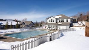 a house with a swimming pool in the snow at Smugglers' Notch Resort 2BR Apartment in Cambridge +13 photos