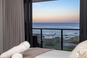 a bedroom with a view of the ocean at Taluga Beach Villa in St. Helena Bay