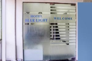 a glass door with a hotel blue light and welcome sign at FabHotel Blue Light in Mumbai