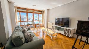 a living room with a couch and a television at Las Vistas in Suances