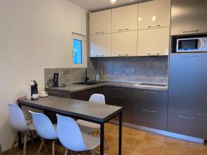 a kitchen with a table and chairs and a refrigerator at Comfort Apartment Becici in Bečići