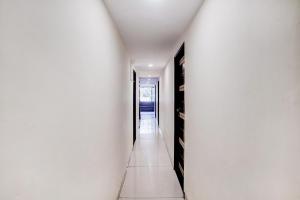 a hallway with white walls and black doors at FabHotel Blue Light in Mumbai