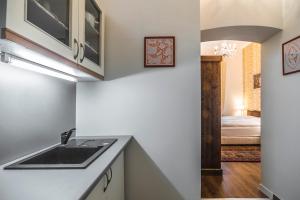 a kitchen with a sink and a room with a bed at CenterCity Apartments in Prešov