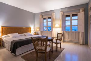 a bedroom with a bed and a table and chairs at Carmen de la Alcubilla del Caracol in Granada