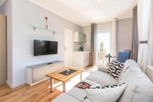 a living room with a couch and a table at Neue Galerie App 3 in Ahrenshoop