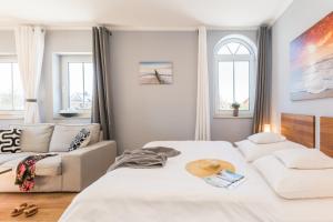 a bedroom with two beds and a couch at Neue Galerie App 3 in Ahrenshoop