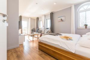 a bedroom with a bed and a living room at Neue Galerie App 3 in Ahrenshoop