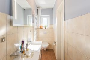 a bathroom with a white sink and a toilet at Neue Galerie App 3 in Ahrenshoop