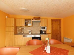a kitchen with a wooden table with chairs and a table sidx sidx at Sterntaucher Bungalow App 5 in Ahrenshoop