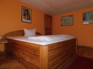 a wooden bed in a room with orange walls at Sterntaucher Bungalow App 5 in Ahrenshoop