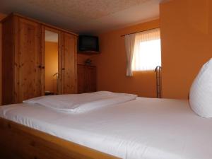 a bedroom with a white bed and a window at Sterntaucher Bungalow App 5 in Ahrenshoop