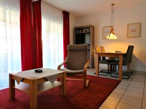 a living room with a chair and a table at Malvenhus in Ahrenshoop