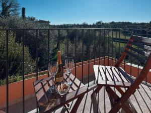 a wooden table with wine bottles and glasses on a balcony at La Casa di Joy in Acquasparta