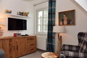 a living room with a tv and a chair at Ostseefeeling in Wustrow