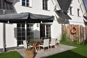 a patio with a table and chairs under an umbrella at Ostseefeeling in Wustrow