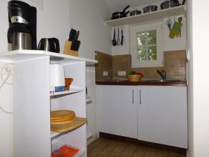 a kitchen with white cabinets and a sink at Puppenhaus in Ahrenshoop