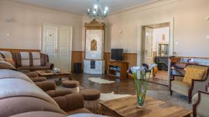 a living room with a couch and a fireplace at Tolcsvai Fogadó in Tolcsva