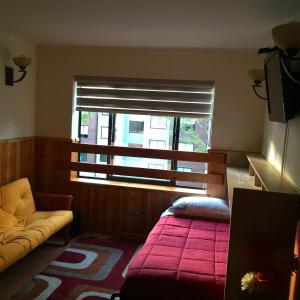 een slaapkamer met een bed en een raam met een rode deken bij Acogedor Departamento en Zona Lacustre in Pucón