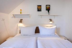 a bed with white sheets and two pillows at Hummer in Althagen +5 photos