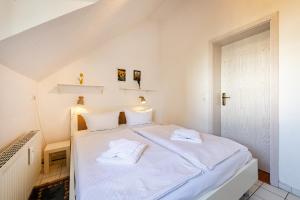 a bedroom with a white bed with two towels on it at Hummer in Althagen