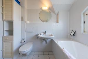 a white bathroom with a toilet and a sink at Hummer in Althagen
