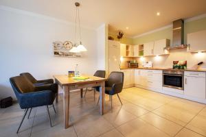 a kitchen and dining room with a table and chairs at Suite Meeresrauschen in Ahrenshoop +10 photos