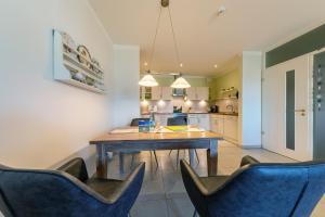a kitchen with a wooden table and blue chairs at Suite Meeresrauschen in Ahrenshoop