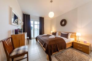 a bedroom with a bed and a chair and a window at Suite Meeresrauschen in Ahrenshoop