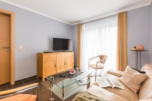 a living room with a couch and a tv at Abendrot in Ahrenshoop