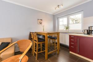 a kitchen with a table and chairs in a room at Abendrot in Ahrenshoop +6 photos