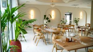 a restaurant with wooden tables and chairs and plants at Park Hotel Żywiec in Żywiec