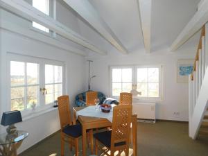 a dining room with a table and chairs and windows at Altes Backhaus 2 in Althagen +3 photos