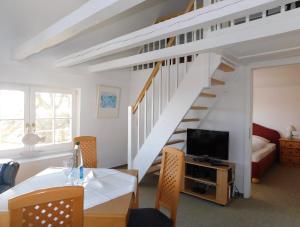 a living room with a dining table and a staircase at Altes Backhaus 2 in Althagen