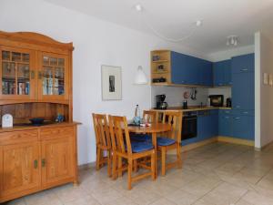 a kitchen with blue cabinets and a table and chairs at Luv in Althagen